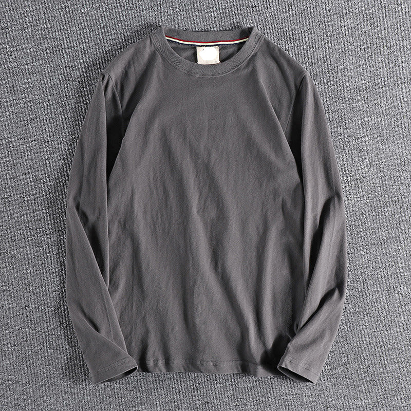 Gray long-sleeve shirt on a textured gray surface