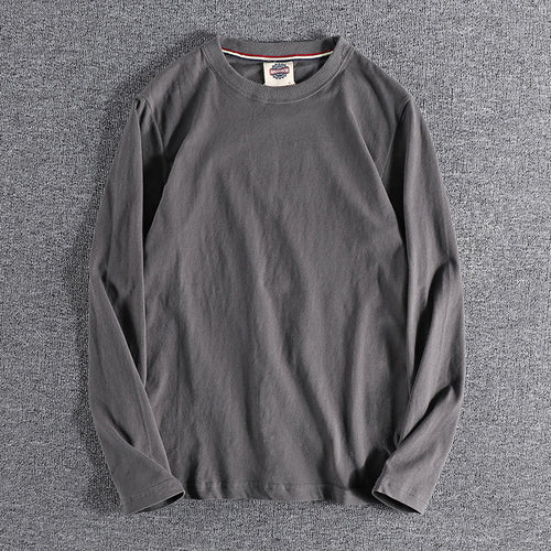 Gray long-sleeve shirt on a textured gray surface