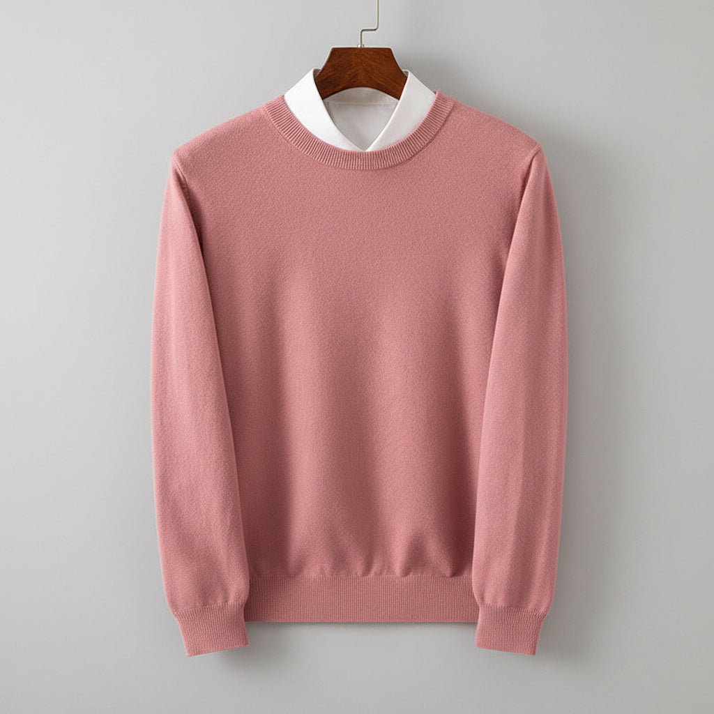 Pink sweater on a hanger against a wooden cabinet background