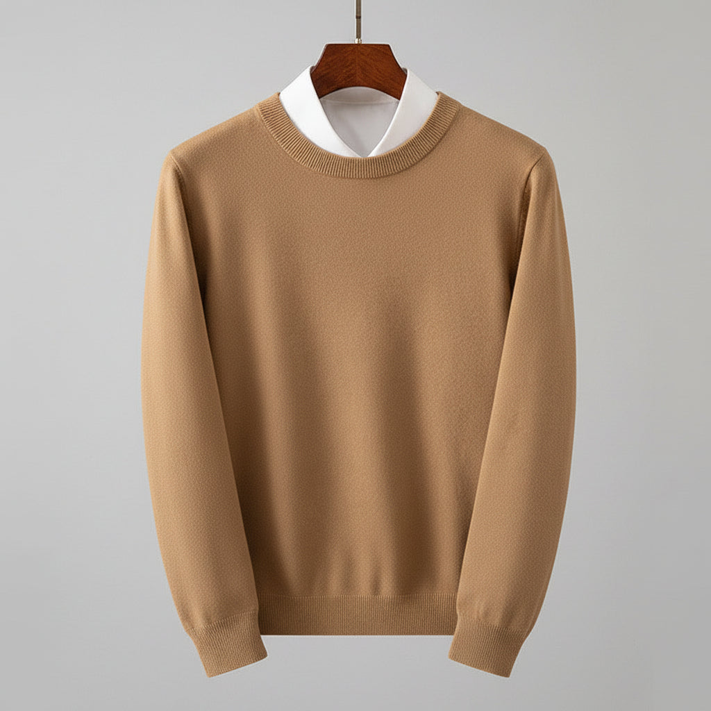 Beige sweater on a hanger with a white shirt underneath, against a wooden dresser background.