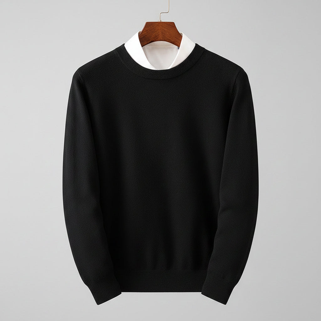 Black sweater on a hanger against a wooden cabinet background
