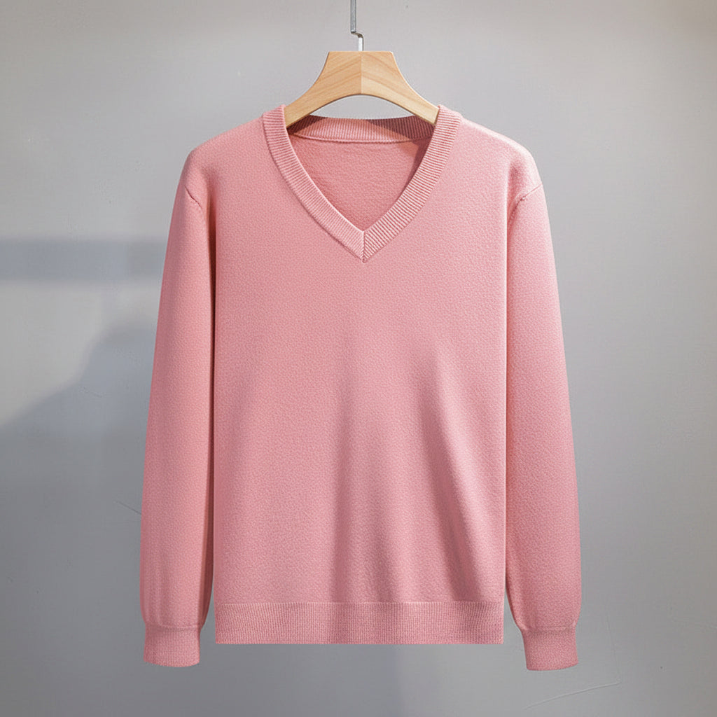 Pink sweater on a hanger against a neutral background
