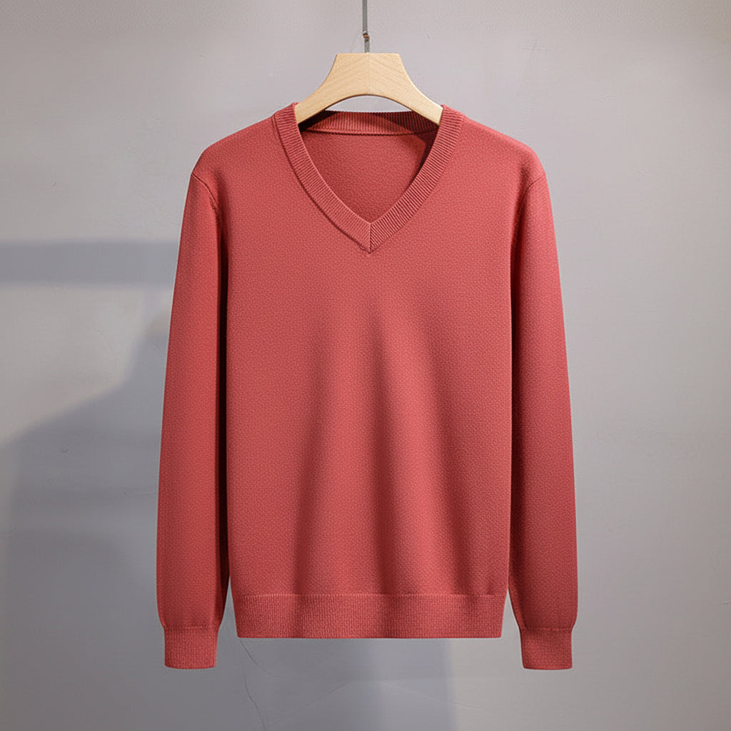 Red sweater on a hanger against a gray background