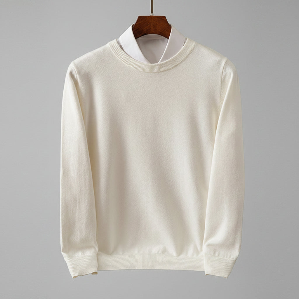 White sweater on a hanger against a dark wooden background