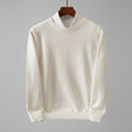 White sweater on a hanger against a dark wooden background