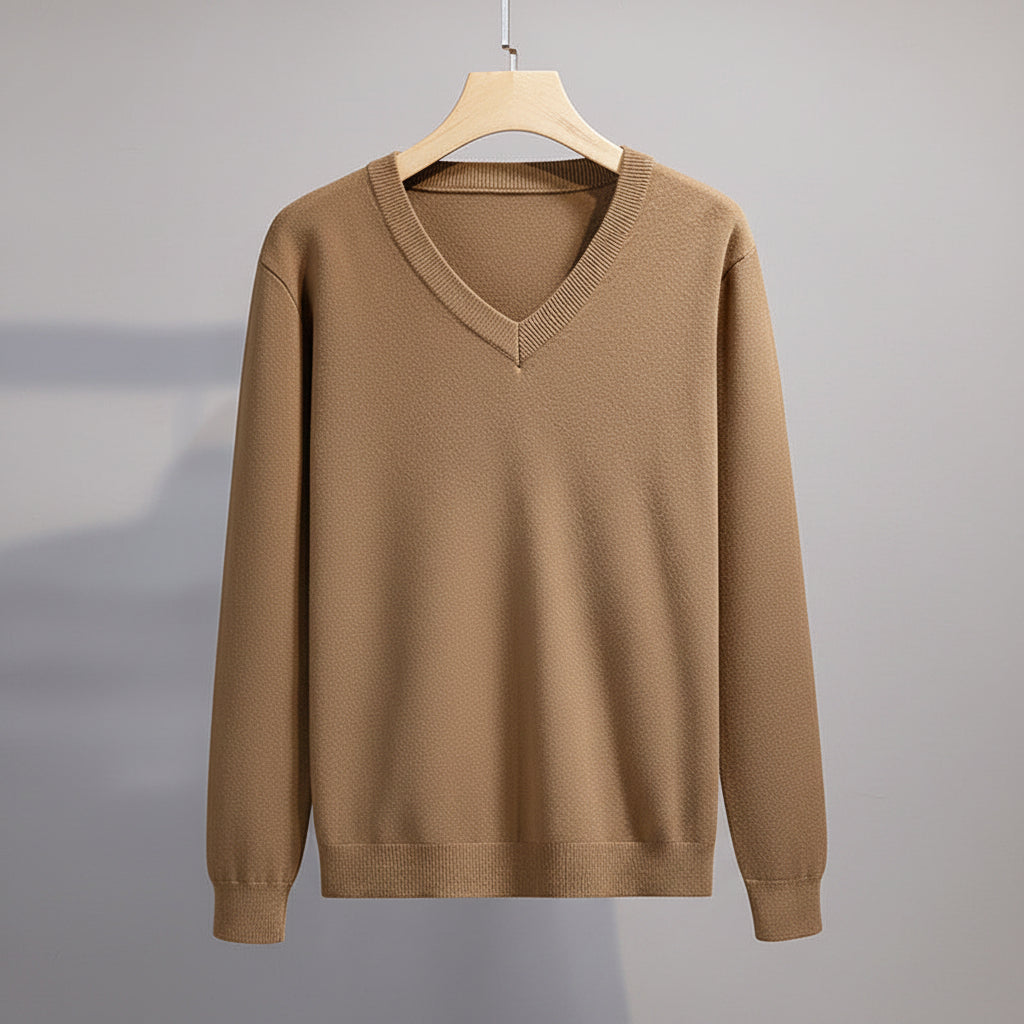 Brown sweater on a hanger against a gray background