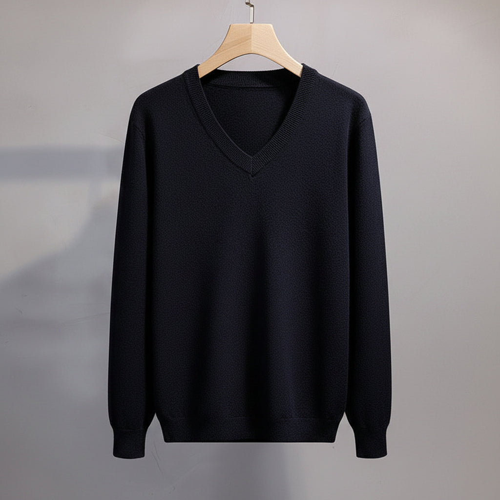 Black sweater on a hanger against a neutral background