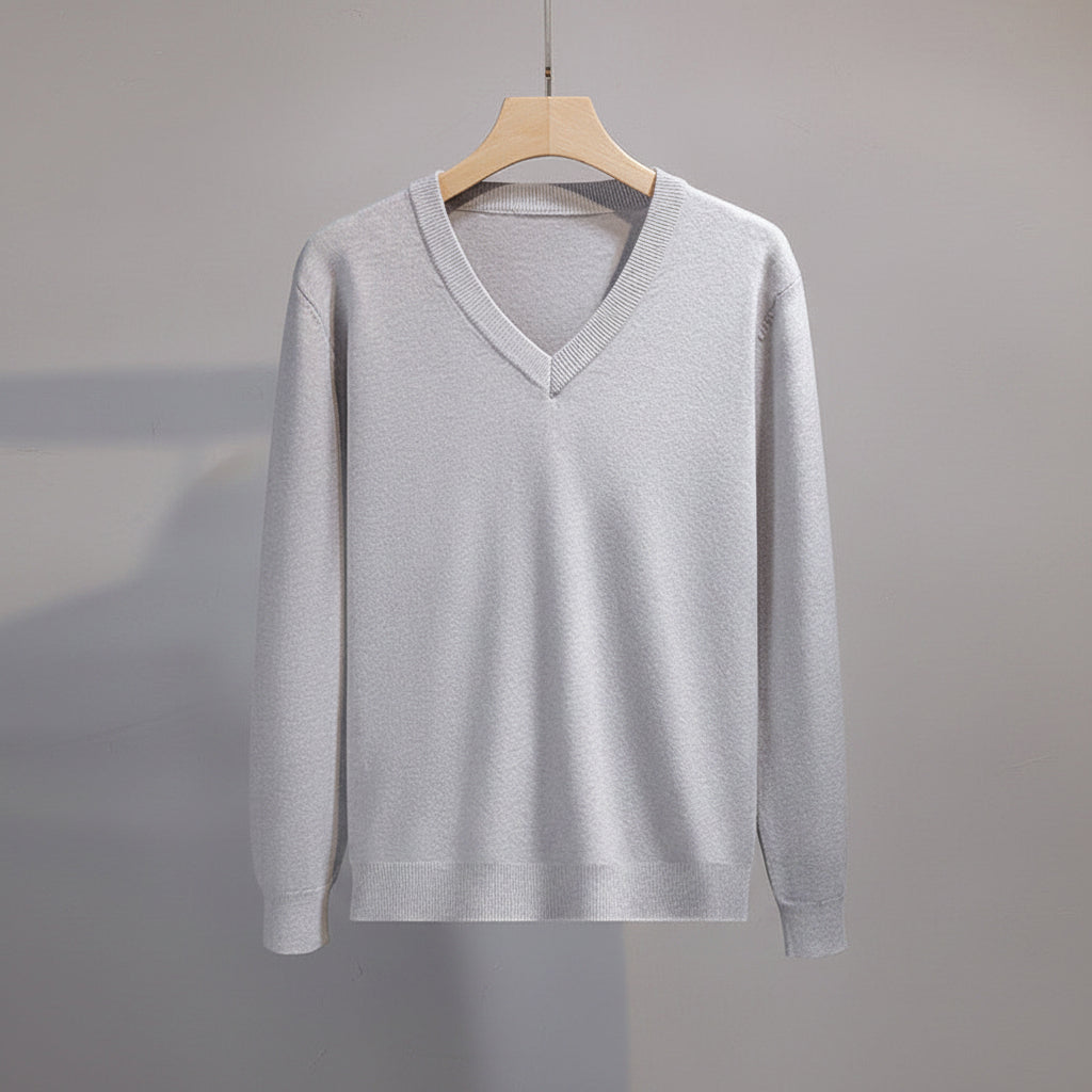 Gray sweater on a hanger with a plain background