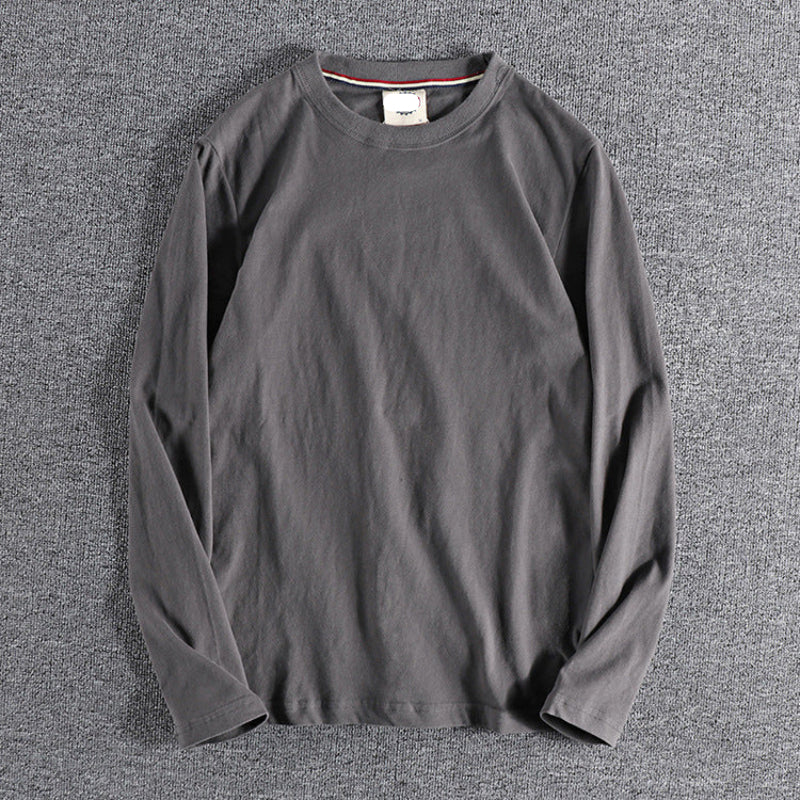 Gray long-sleeve shirt on a textured gray surface
