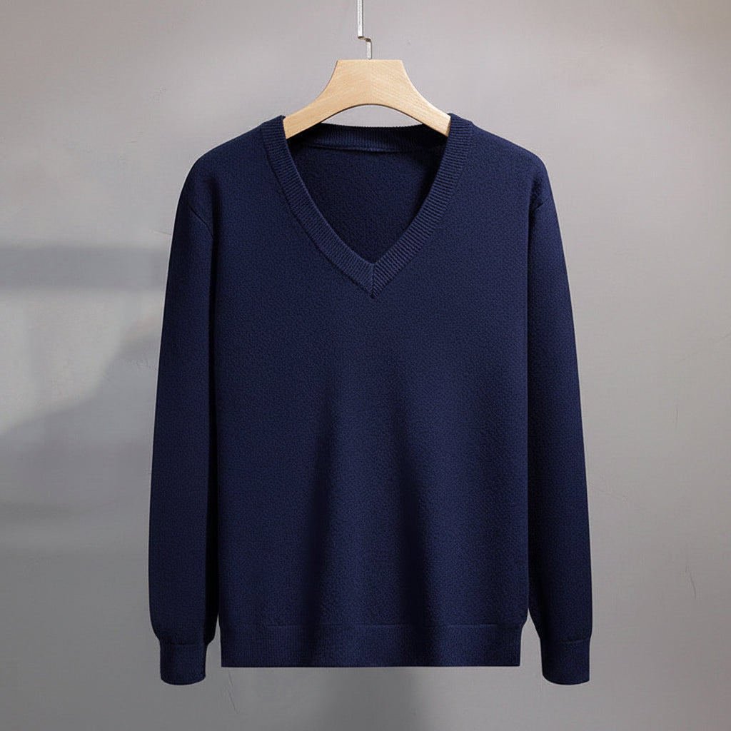 Navy blue sweater on a hanger against a gray background
