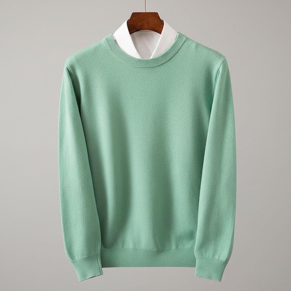 Green sweater on a hanger against a wooden cabinet background