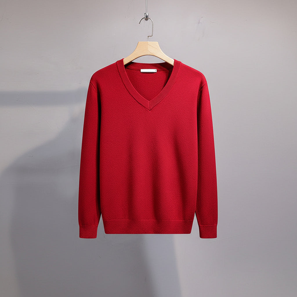 Red sweater on a hanger against a gray background