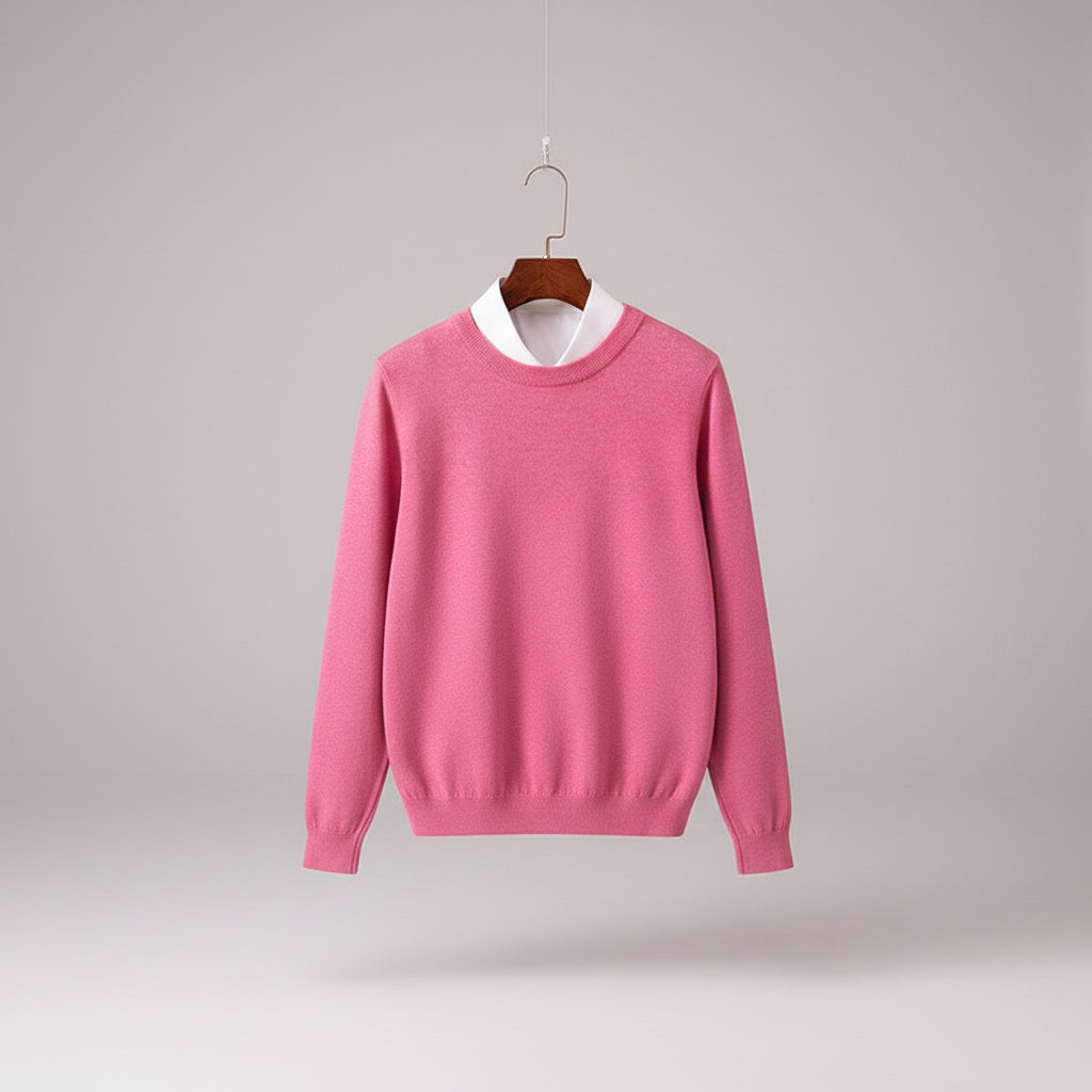 Pink sweater on a wooden hanger with a white shirt underneath