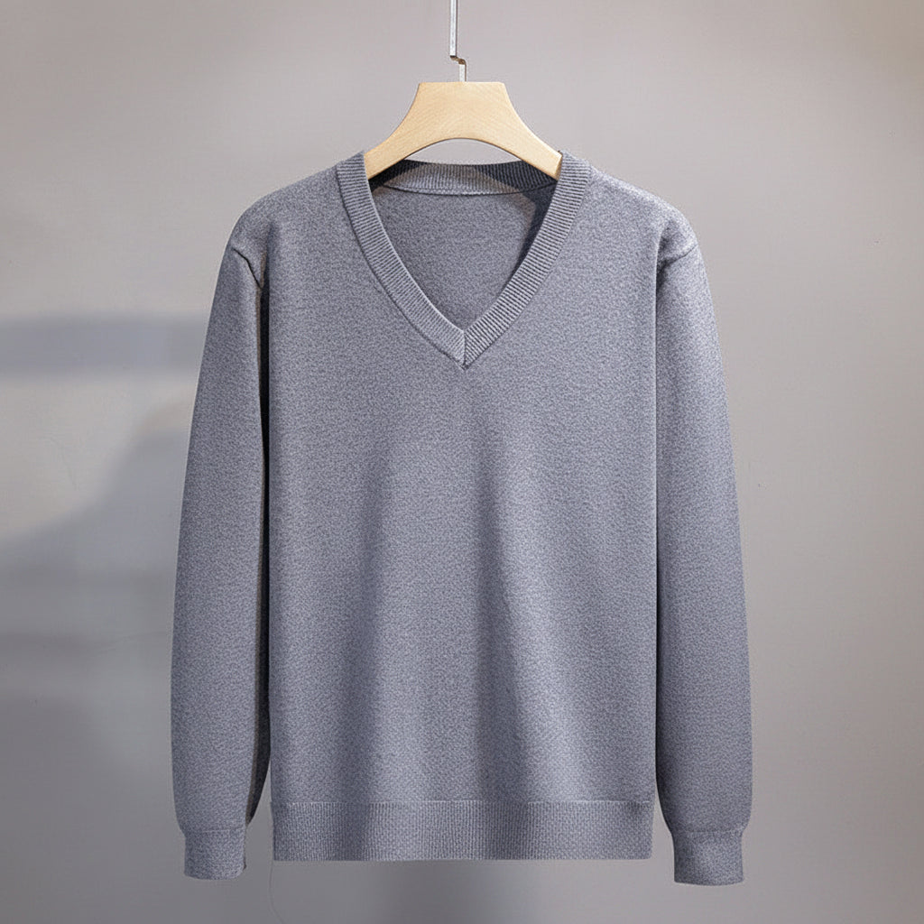Gray sweater on a hanger against a neutral background