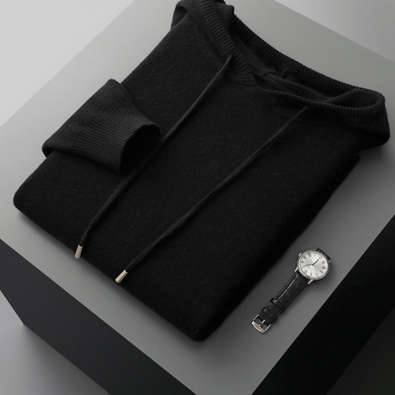Black sweater and watch on a gray surface