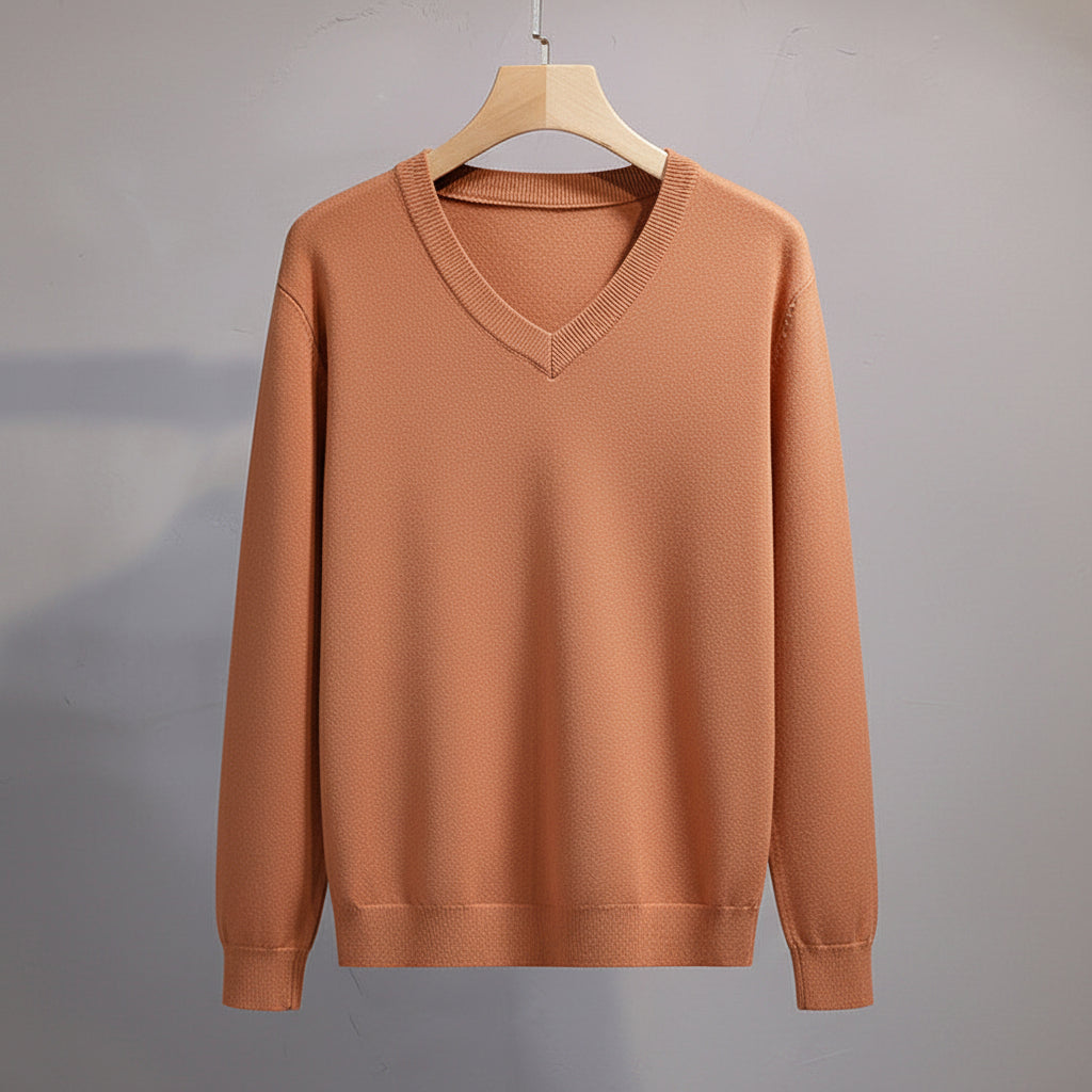 Brown sweater on a hanger against a neutral background